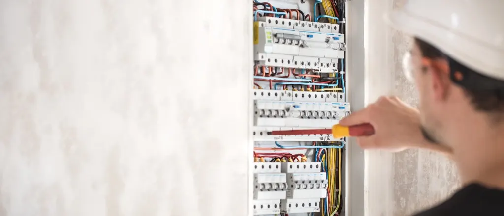 Elektryk sprawdzający rozdzielnicę domową z zabezpieczeniami
